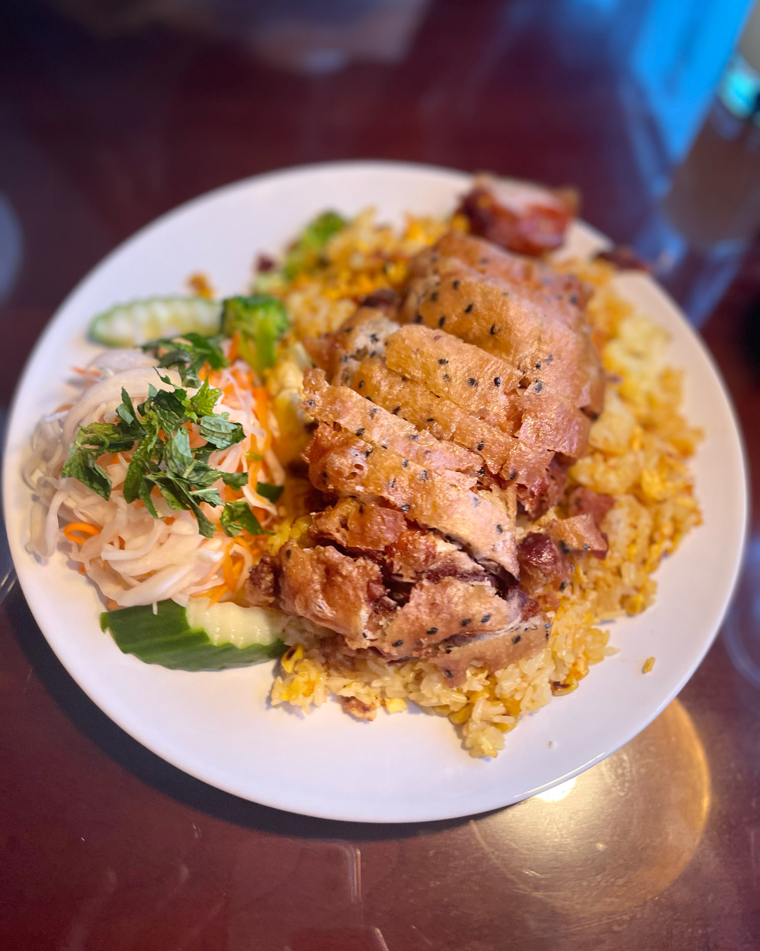 En tallrik stekt ris med anka, inlagda grönsaker och gurka